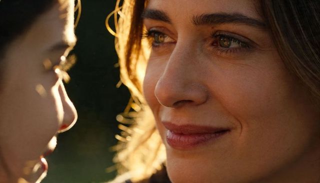 Smiling woman gazing at partner during golden hour close-up, backlit intimate portrait