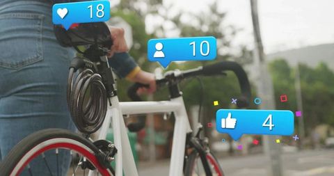 Cyclist Engaging with Social Media Icons in Urban Environment