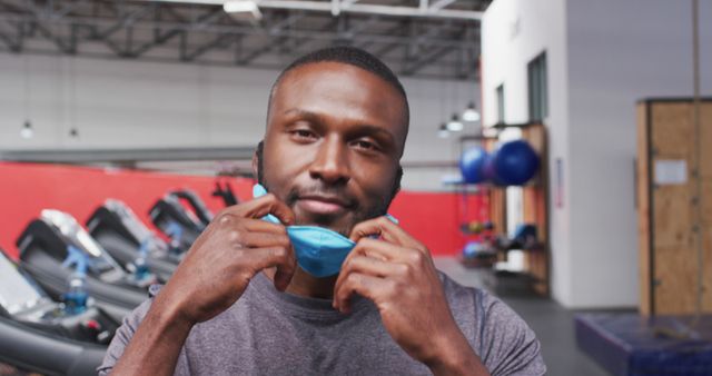 Man at Gym Removing Face Mask Post-Workout - Download Free Stock Images Pikwizard.com