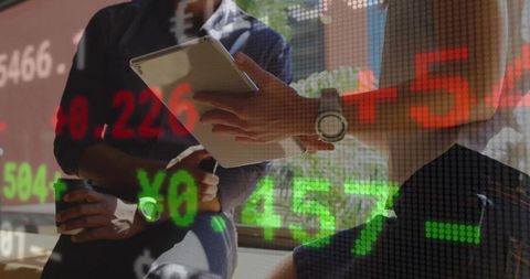 Business Colleagues Analyzing Stock Market Data on Tablet in Office Setting