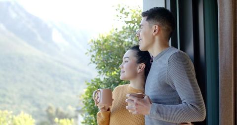 Couple Enjoying Scenic Mountain View with Morning Coffee