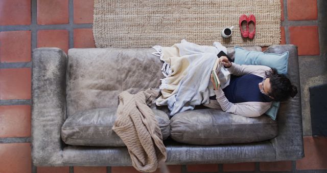 Top View of Woman Relaxing on Couch with Blanket and Book - Download Free Stock Images Pikwizard.com