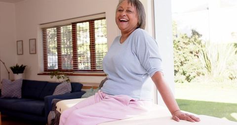 Senior Woman Smiling in Bright Living Room Expressing Joy and Contentment