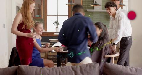 Friends gathering in open-plan living room holding glasses laughing chatting together