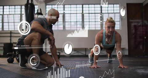 Female athlete holding plank while coach guiding strength training with data hud