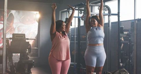 Diverse mid-adult women stretching in gym activewear celebrating fitness and friendship