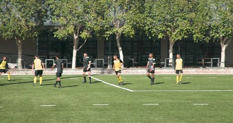 Soccer players practicing teamwork on sunny day field