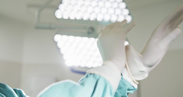 Surgeon Putting on Medical Gloves Under Surgical Lights - Download Free Stock Images Pikwizard.com