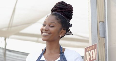 Smiling female vendor at community marketplace stall