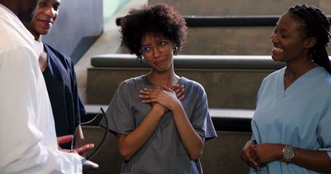 Smiling medical professional receiving an award from coworkers