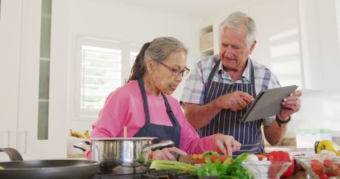 Senior Couple Enjoying Cooking Together While Using Tablet - Download Free Stock Images Pikwizard.com