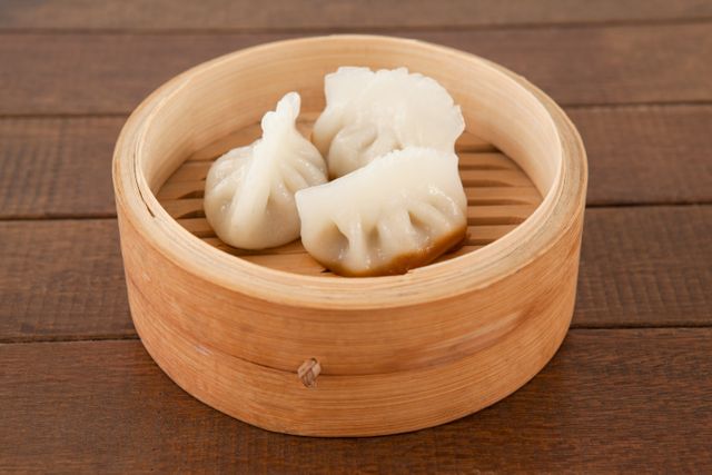 This image showcases a close-up view of dumplings in a bamboo steamer, highlighting the texture and traditional presentation of Asian cuisine. Perfect for use in food blogs, restaurant menus, culinary websites, and cultural articles about Chinese food and dim sum.