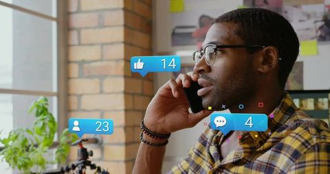 Remote creator talking on phone with social media notifications in bright studio workspace