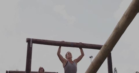 Woman Performing Pull-Up at Outdoor Obstacle Training Park