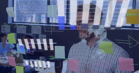 Executive planning on glass wall with data charts and sticky notes in modern office
