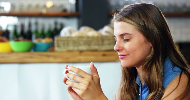 Young woman drinking coffee in cozy cafe, enjoying soothing moment - Download Free Stock Images Pikwizard.com