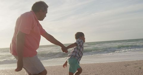 Grandfather and Grandson Run Together on Scenic Beach - Download Free Stock Images Pikwizard.com