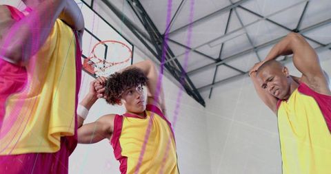 Basketball Players Stretching in Gym Before Game
