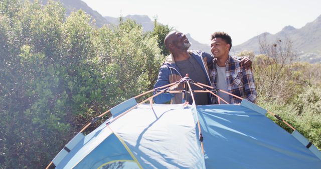 Father and son bonding while setting up tent in beautiful mountain scenery - Download Free Stock Images Pikwizard.com