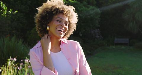 Joyful Woman Smiling in Sunlit Garden Setting