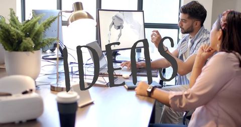 Collaborating on 3d robotic arm design at desk with monitor, daylight and modern workspace