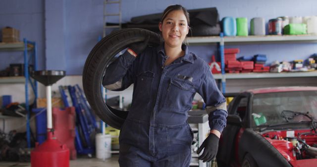 Female Auto Mechanic Carrying a Tire in a Garage - Download Free Stock Images Pikwizard.com