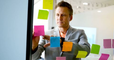 Businessman Brainstorming with Sticky Notes on Glass Wall - Download Free Stock Images Pikwizard.com