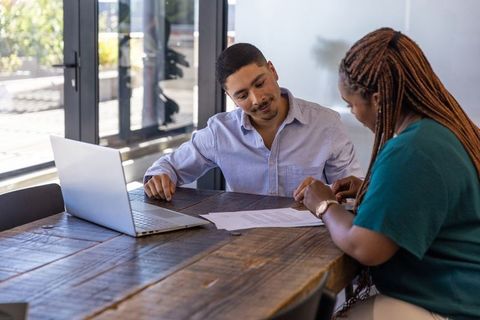 Diverse Professionals Analyzing Document in Modern Office Workspace