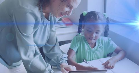 Teacher Guiding Young Student with Tablet Technology