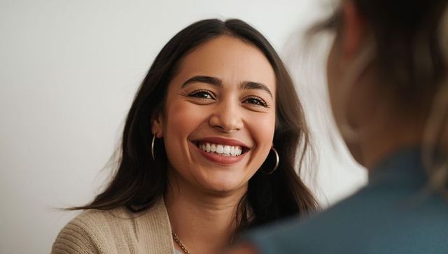 Smiling Hispanic Woman with Hoop Earrings Engaging in Conversation