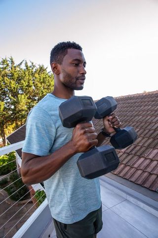 Determined Man Lifting Weights Outdoors Promoting Healthy Lifestyle