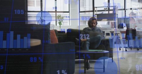 Man Using Laptop with Statistical Data Displayed in Office - Download Free Stock Images Pikwizard.com