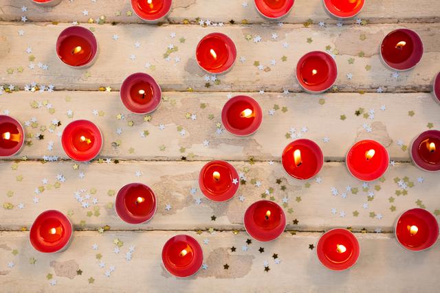 Candles burning on wooden plank during christmas time