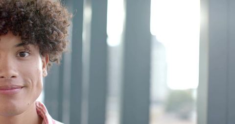 Young Hispanic Man Standing on Urban Balcony Wearing Red Striped Shirt with City View