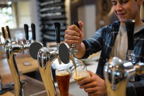 Bartender Pouring Craft Beer at Bar with Industrial Decor - Download Free Stock Images Pikwizard.com