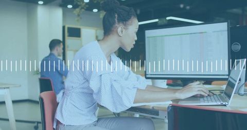 Focused Businesswoman Analyzing Financial Data on Laptop in Modern Office