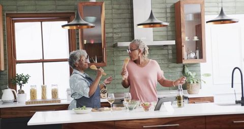 Senior African American Women Singing and Cooking in Kitchen