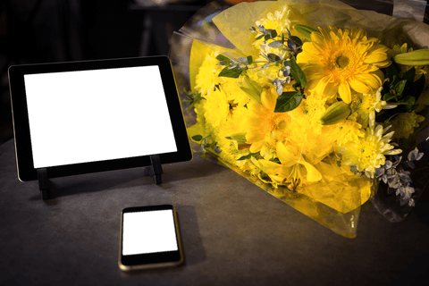 Transparent screens with yellow flower bouquet on modern workspace