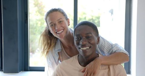 Smiling Diverse Couple Embracing in Modern Home Interior