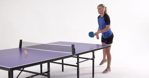 Female Athlete Playing Ping Pong in Studio Setting