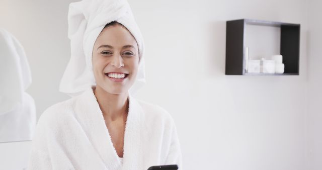 Happy Woman in Towel Robe Using Smartphone in Modern Bathroom - Download Free Stock Images Pikwizard.com