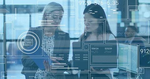 Two colleagues collaborating over tablet with futuristic data overlays in modern office