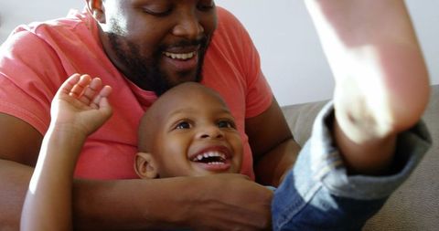 Father and Son Enjoying Playful Moments on Cozy Sofa