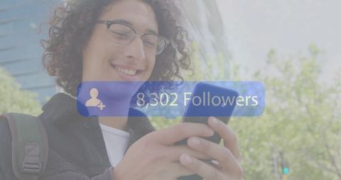 Man smiling checking smartphone on city street with followers notification