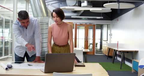 Business Professionals Collaborating on Blueprint in Modern Office