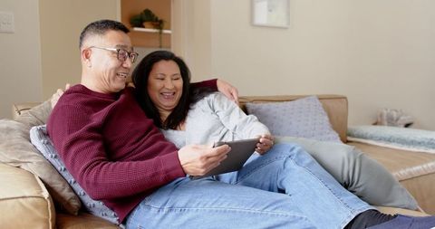 Couple Relaxing with Tablet on Cozy Sofa