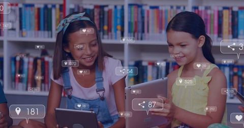 Young Students Using Tablets in Library with Social Media Icons Showing Engagement