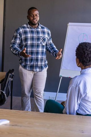 Colleagues Presenting Pie Chart During Business Meeting in Modern Office