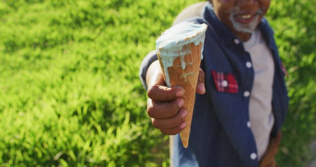 Smiling Older Man Offering Ice Cream Cone in Sunny Park - Download Free Stock Images Pikwizard.com