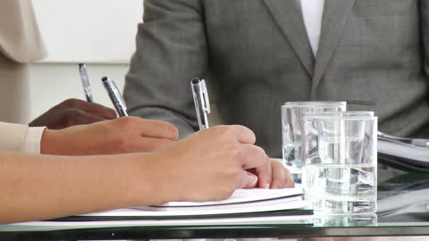 Close Up of Professionals Taking Notes in a Meeting